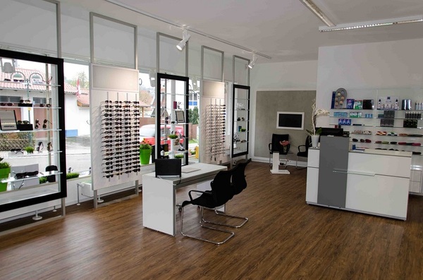 Modernes Optiker-Geschäft mit Brillenregalen, Beratungstisch und stilvoller Einrichtung.